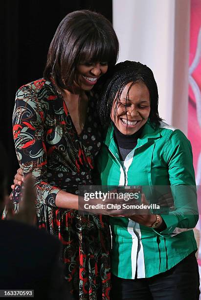 First lady Michelle Obama embraces women's rights advocate Dr. Josephine Obiajulu Odumakin of Nigeria after she received her International Women of...