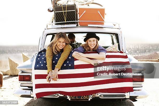two girls smiling from the back of a car. - american culture stock pictures, royalty-free photos & images