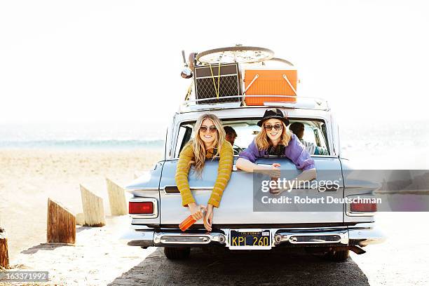 two girls drinking soda in the back of a car. - drinking soda in car stock pictures, royalty-free photos & images
