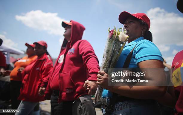 People watch a live broadcast of the funeral for Venezuelan President Hugo Chavez outside the Military Academy on March 8, 2013 in Caracas,...