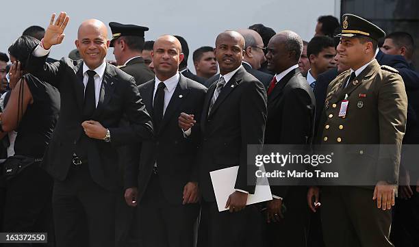 Haitian President Michel Martelly waves to the crowd while departing the funeral for Venezuelan President Hugo Chavez at the Military Academy on...