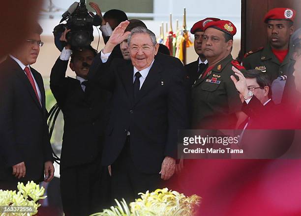 Cuban President Raul Castro waves to the crowd before entering the funeral for Venezuelan President Hugo Chavez at the Military Academy on March 8,...