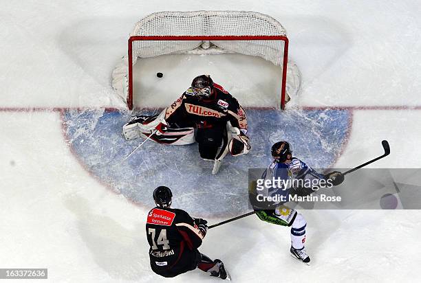 Blaine Down of Straubing scores his team's winning goal over Dimitri Paetzold , goaltender of Hannover during the DEL match between Hannover...