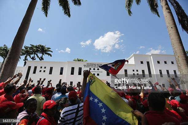 People wave and applaud as dignitaries arrive for the funeral for Venezuelan President Hugo Chavez outside the Military Academy on March 8, 2013 in...