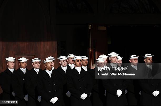 Navy ceremonial team members await the beginning of a funeral service at Arlington National Cemetery for two unknown sailors who were killed in 1862...