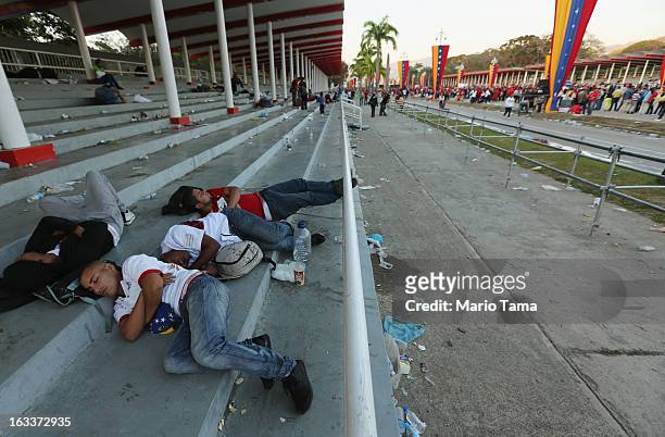 People sleep as others wait in line before the funeral for Venezuelan President Hugo Chavez outside the Military Academy on March 8, 2013 in Caracas,...