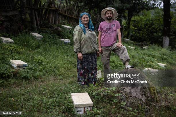 Year-old beekeeper Melahat Gulbin and son Taner Gulbin pose for a portrait amid their Caucasian queen bee breeding boxes on August 17, 2023 in...