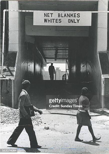 Two black people pass a "Net Blankes, Whites Only" sign on October 7, 1977 in South Africa.