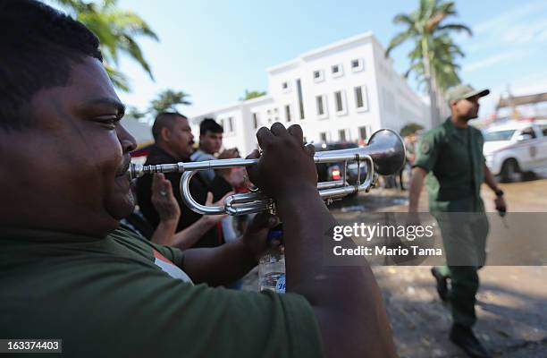 Mario Escalona plays a horn before the funeral for Venezuelan President Hugo Chavez outside the Military Academy on March 8, 2013 in Caracas,...