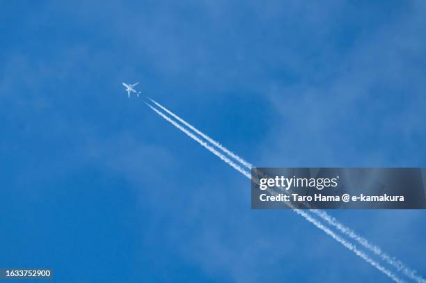 the airplane flying in the sunset sky over kanagawa of japan - vapor fotografías e imágenes de stock
