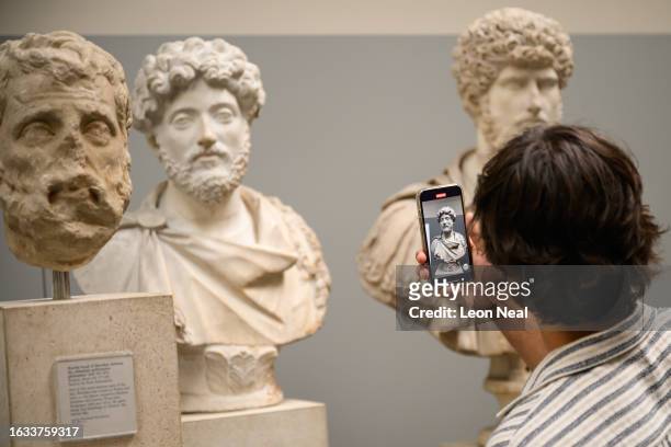 Visitor to the British Museum takes a photograph of a selection of Greek marble busts on August 23, 2023 in London, England. British Museum officials...