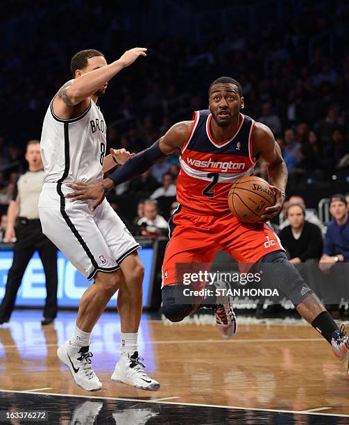 John Wall of the Washington Wizards drives against Deron Williams of the Brooklyn Nets at the Barclay Center March 8, 2013 in the Brooklyn borough of...