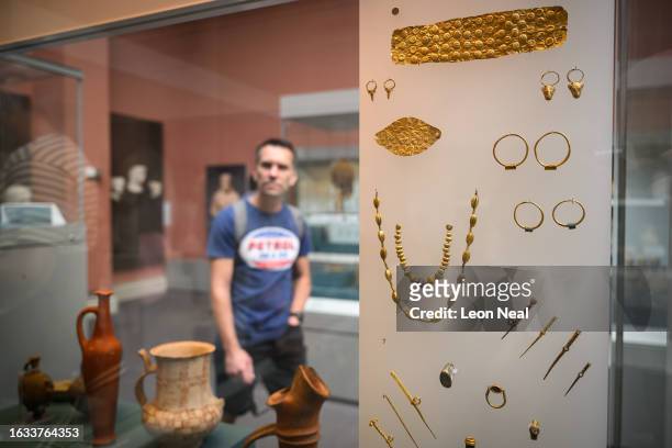 Visitor to the British Museum walks past a display case containing Cypriot jewellery from around 1750BC, on August 23, 2023 in London, England....