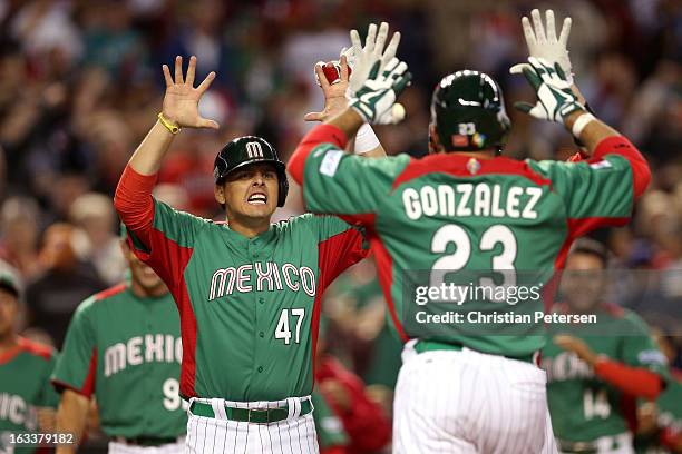 Luis Cruz of Mexico greets teammate Adrian Gonzalez after they both scored on a 2-run home run by Gonzalez in the top of the third inning against the...