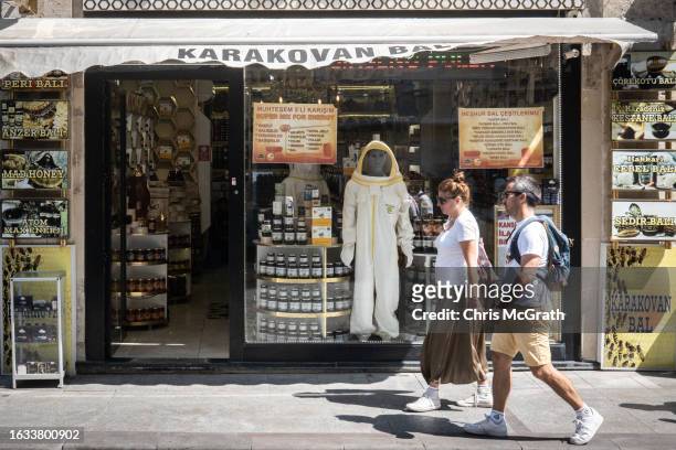 People walk on the street past a shop specialising in honey products on August 23, 2023 in Istanbul, Turkey. Turkey is the world's second largest...