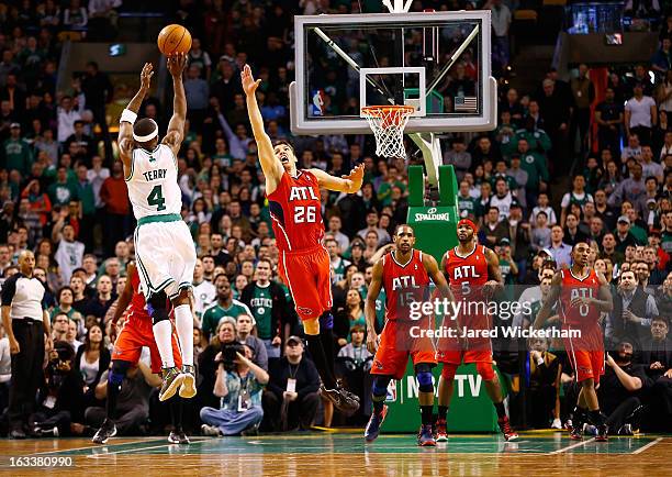 Jason Terry of the Boston Celtics makes a three-point shot in the final minute of overtime in front of Kyle Korver of the Atlanta Hawks during the...