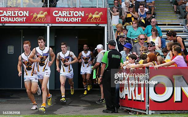 Hawthorn Hawks players run out after their three quarter time break was taken in the rooms due to the heat during the round three NAB Cup AFL match...