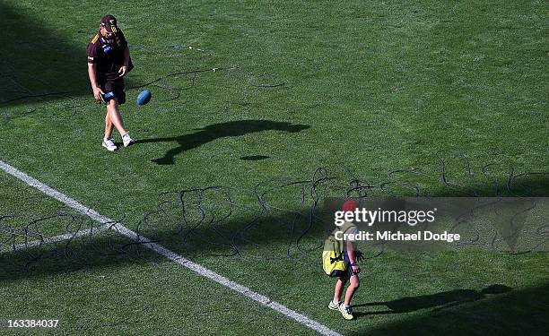 Hawthorn Hawks coach Alastair Clarkson kicks the ball with his son on the way to the bus during the round three NAB Cup AFL match between the...