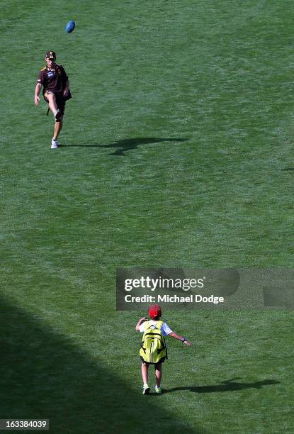 Hawthorn Hawks coach Alastair Clarkson kicks the ball with his son on the way to the bus during the round three NAB Cup AFL match between the...
