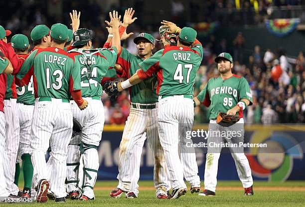 Eduardo Arredondo and Luis Cruz of Mexico celebrate with their teammates after they won 5-2 against the United States during the World Baseball...