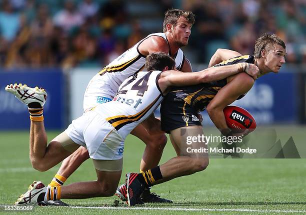 Dustin Martin of the Richmond Tigers gets tackled by Ben Stratton of the Hawthorn Hawks during the round three NAB Cup AFL match between the Hawthorn...
