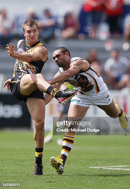 Dustin Martin of the Richmond Tigers kicks the ball away from Shaun Burgoyne of the Hawthorn Hawks during the round three NAB Cup AFL match between...