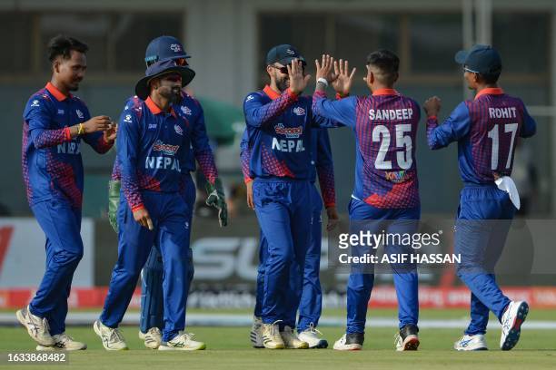 Nepal's Sandeep Lamichhane celebrates with teammates after taking the wicket of Pakistan's Agha Salman during the Asia Cup 2023 cricket match between...