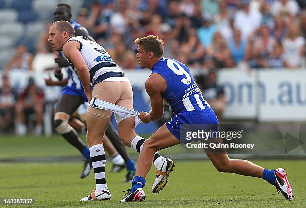 James Kelly of the Cats has his shorts pull down by Andrew Swallow of the Kangaroos during the round three NAB Cup AFL match between the Geelong Cats...