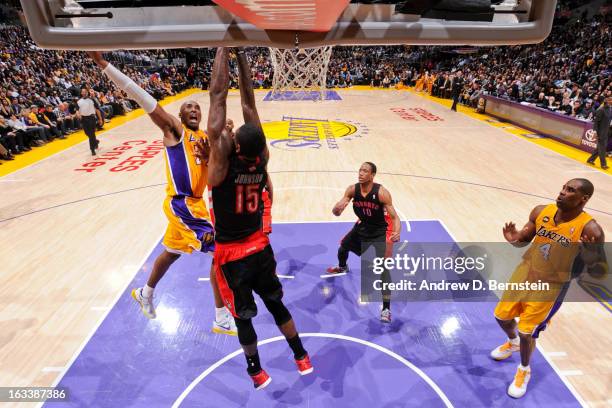 Kobe Bryant of the Los Angeles Lakers rises for a dunk against Amir Johnson of the Toronto Raptors at Staples Center on March 8, 2013 in Los Angeles,...