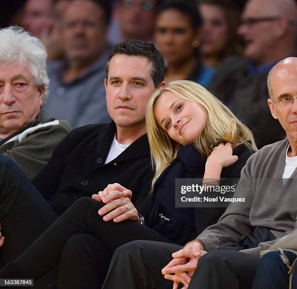 Reese Witherspoon and her husband Jim Toth attend a basketball between Toronto Raptors and Los Angeles Lakers at Staples Center on March 8, 2013 in...