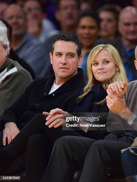 Reese Witherspoon and her husband Jim Toth attend a basketball between Toronto Raptors and Los Angeles Lakers at Staples Center on March 8, 2013 in...