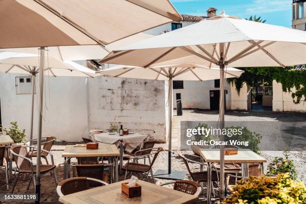 corner of a outdoor restaurant with empty tables and seats in spain - café esplanada imagens e fotografias de stock