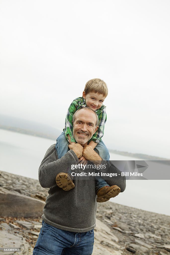 A day out at Ashokan lake. A man giving a child a shoulder ride.