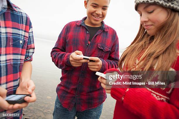 a day out at ashokan lake. teenagers, a girl and two boys texting and looking at their cell phones.  - ashokan reservoir stock pictures, royalty-free photos & images