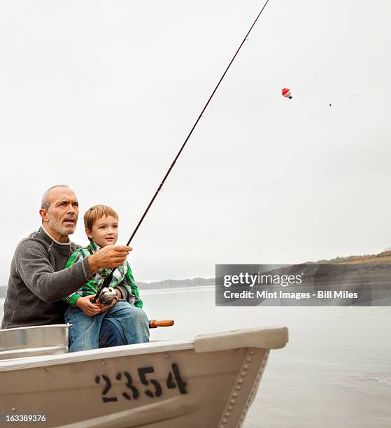 a day out at ashokan lake. a man showing a young boy how to fish, sitting in a  boat. - ashokan reservoir stock pictures, royalty-free photos & images