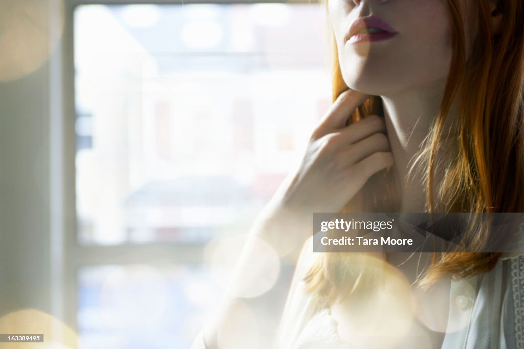 Woman touching her hair with lens flare