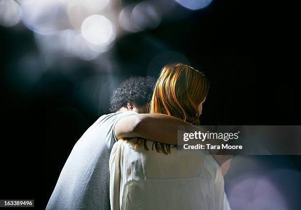 man hugging woman with lens flare - femmes de dos enlacée photos et images de collection