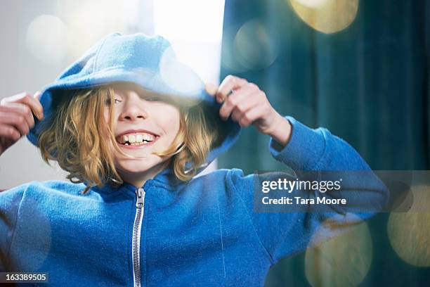 young girl pulling hood over head - camisa con capucha fotografías e imágenes de stock