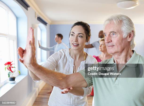 teacher and student in community exercise class - taijiquan photos et images de collection