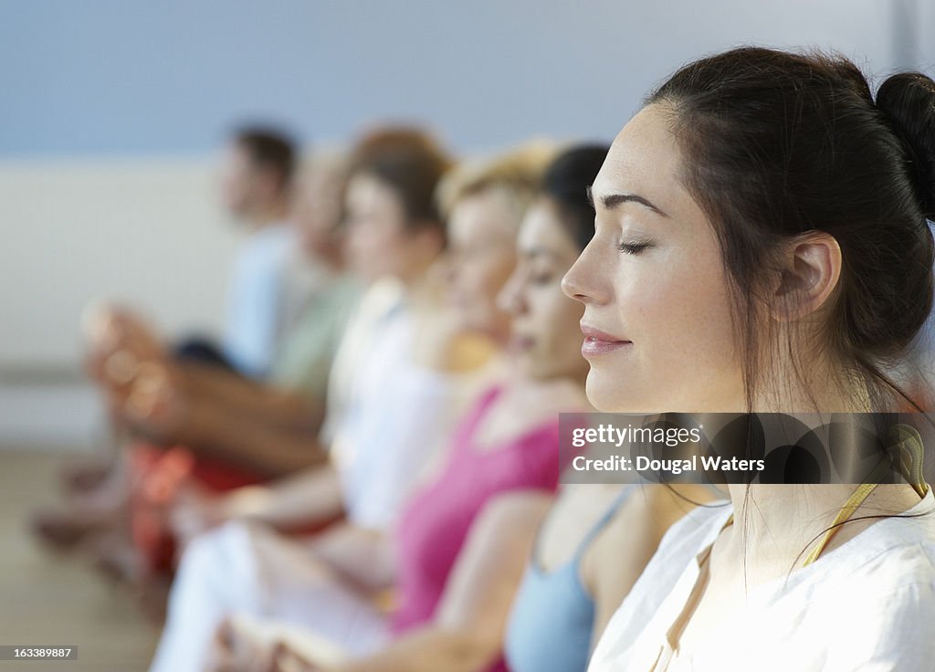 Profile of woman with eyes closed, in group