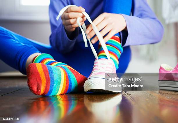 young child tying shoe laces with colourful socks - schuhwerk stock-fotos und bilder