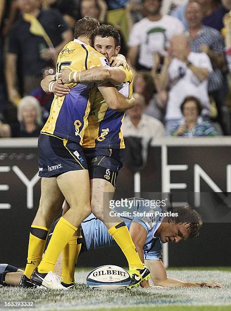 Robbie Coleman of the Brumbies is congratulated by Jesse Mogg after scoring a try during the round four Super Rugby match between the Brumbies and...