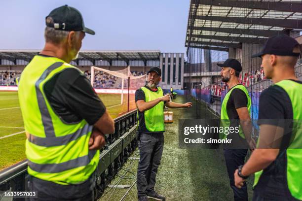 les agents de sécurité discutent sur le terrain - security guard photos et images de collection