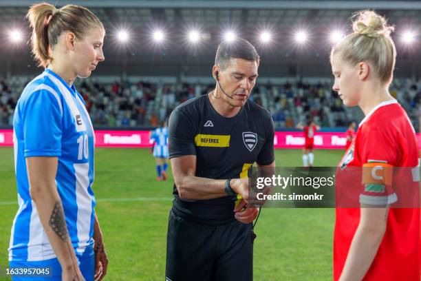 referee with team captions on football pitch - referee shirt stock pictures, royalty-free photos & images