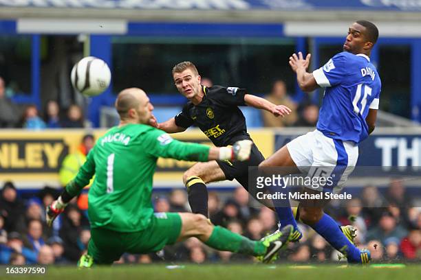 Callum McManaman of Wigan Athletic scores his sides third goal as Sylvain Distin and goalkeeper Jan Mucha of Everton look on during the FA Cup Sixth...
