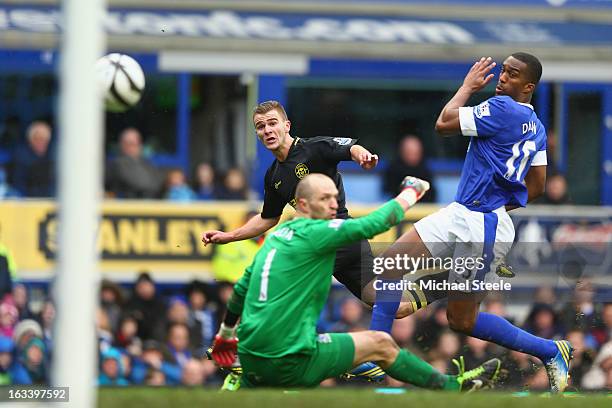 Callum McManaman of Wigan Athletic scores his sides third goal as Sylvain Distin and goalkeeper Jan Mucha of Everton look on during the FA Cup Sixth...