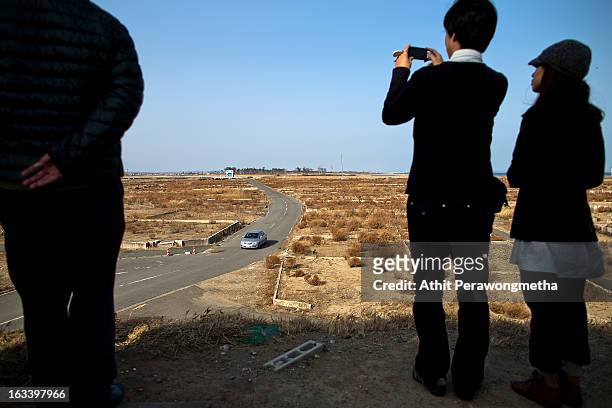 Local people take pictures from a view prior to the second anniversary of the earthquake and tsunami on March 9, 2013 in Natori, Japan. On March 11...