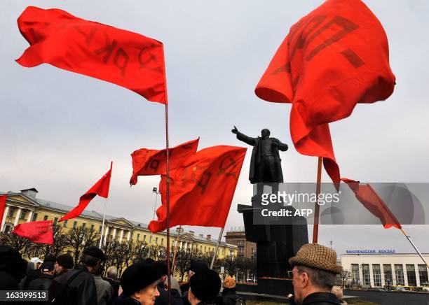 Supporters of the Communist Party gather with red flags in front of a monument to the founder of the Soviet Union Vladimir Lenin in Saint Petersburg...