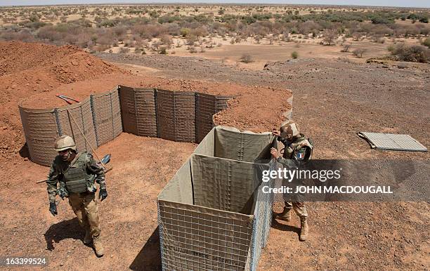 French soldiers of an engineering unit build a defensive position to protect the airport in Gao on March 9 where the French forces have established...