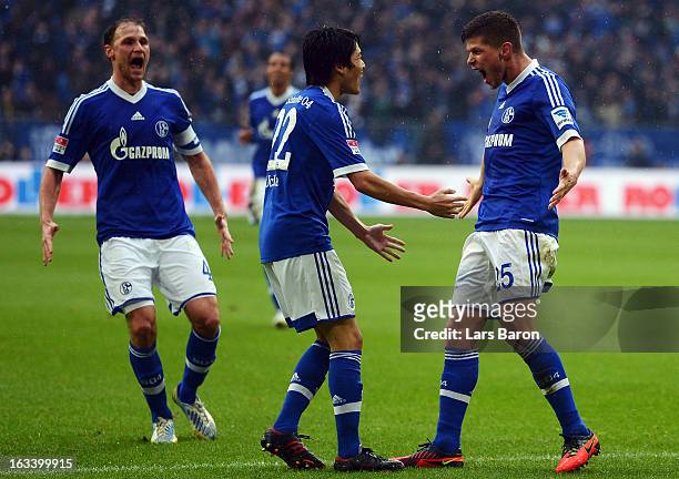 Klaas Jan Huntelaar of Schalke celebrates with Atsuto Uchida and other team mates after scoring his teams second goal during the Bundesliga match...